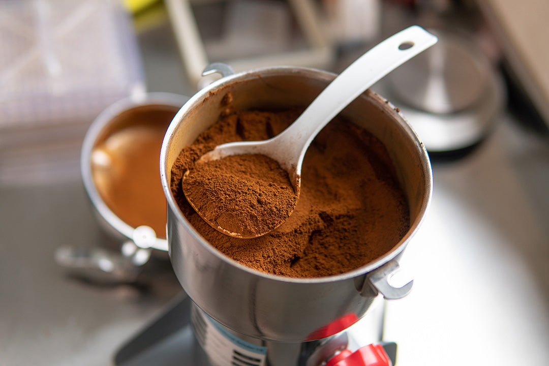 A scoop of mushroom powder in a metal container, highlighting the comparison between mushroom extract and powder in functional mushroom supplements.